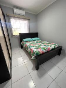 a bedroom with a bed with a floral comforter at Casa espaçosa com 3 quartos climatizados in Petrolina