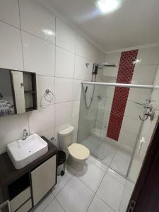 a bathroom with a shower and a toilet and a sink at Casa espaçosa com 3 quartos climatizados in Petrolina +6 photos