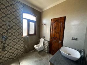 a bathroom with a sink and a toilet and a window at The Landing Nest - Villa in Srinagar