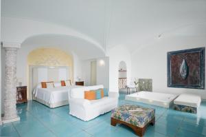 a bedroom with a bed and a couch and a table at Hotel Santa Caterina in Amalfi +136 photos