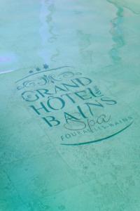 a sign in the water in a swimming pool at Grand Hôtel des Bains SPA in Fouras