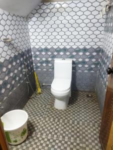 a bathroom with a toilet and a bucket in it at Sree durga Villa Homestay in Kodoth