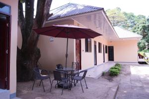 a patio with a table and chairs and an umbrella at Hotel near the clock tower in Arusha