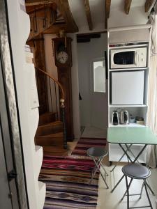 a small kitchen with a table and a microwave at Deux chambres en plein cœur de Montmartre, Paris in Paris +11 photos