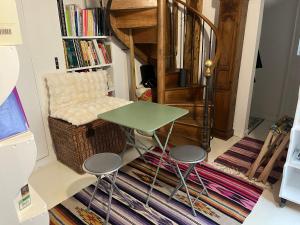 a table and stools in a room with a book shelf at Deux chambres en plein cœur de Montmartre, Paris in Paris