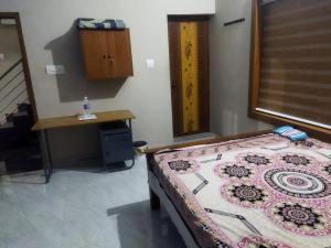 a room with a bed and a table and a desk at Sree durga Villa Homestay in Kodoth +6 photos
