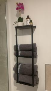 a black towel rack with towels and a plant at À Lens comme à la maison in Lens