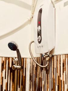 a blow dryer on the wall of a bathroom at Atrium Cottage in Seeduwa