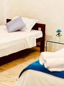 a bedroom with two beds and a glass table at Atrium Cottage in Seeduwa