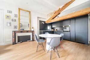 a dining room with a table and chairs and a fireplace at Superbe Appartement Intramuros in Avignon