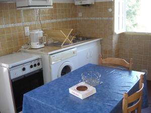 a kitchen with a table with a blue table cloth at Guéraçague Etcheverry Garaya in Saint-Jean-Pied-de-Port