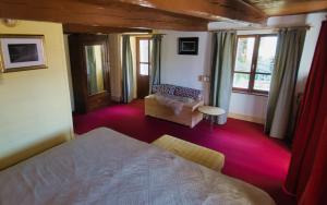 a bedroom with a bed and a couch and windows at Stones and Pines in Rimella