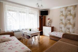 a room with a bed and a table and a couch at NOCLEGI Święta Katarzyna CENTRUM in Święta Katarzyna