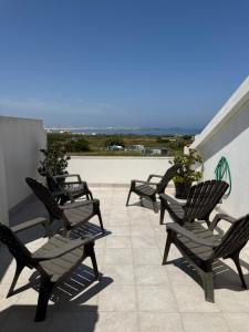 a row of lawn chairs sitting on a patio at Baleal Atlantic View House in Baleal