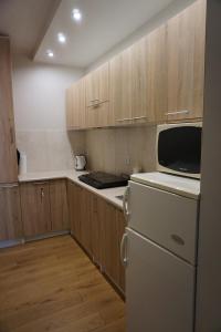 a kitchen with a white refrigerator and wooden cabinets at NOCLEGI Święta Katarzyna CENTRUM in Święta Katarzyna +15 photos
