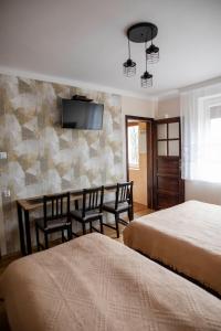 a hotel room with two beds and a table and chairs at NOCLEGI Święta Katarzyna CENTRUM in Święta Katarzyna