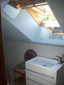a bathroom with a sink and a ceiling with a window at La maison bois in Chaon