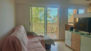 a living room with a couch and a television at Appartement Stella vue mer in Piles