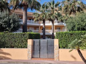 a building with palm trees in front of it at Appartement Stella vue mer in Piles