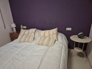 a bed with white sheets and pillows in a bedroom at Appartement Stella vue mer in Piles +8 photos