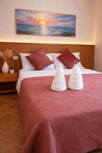 a bedroom with a large bed with red sheets and pillows at RV3 TRANSIENT HOUSE in Angeles