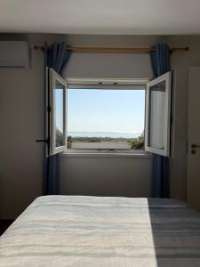 a bedroom with a bed and a window with a view at Baleal Atlantic View House in Baleal
