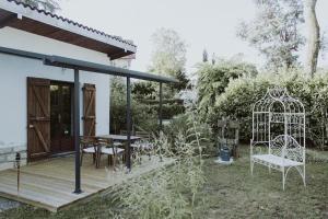 a wooden deck with a gazebo and a table at Le Chalet de la Leyre in Le Teich