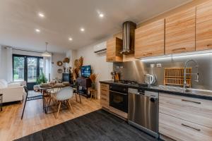 a kitchen with stainless steel appliances and a living room at Le Chalet de la Leyre in Le Teich