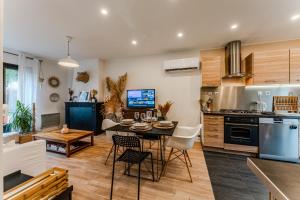 a kitchen and living room with a table and chairs at Le Chalet de la Leyre in Le Teich +7 photos