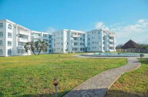 a walkway in front of a large apartment building at Kijani Luxury Beach apartment in Malindi
