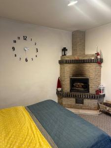 a bedroom with a fireplace and a clock on the wall at Гостьовий двір in Yaremche