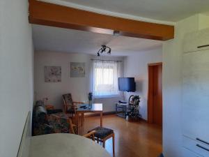 a living room with a table and a couch at Ferienwohnung Albus in Albertshausen