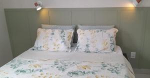 a bed with two pillows and a blanket on it at Garden House Canastra in Delfinópolis