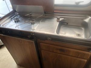 a kitchen with a sink and a stove at Autocaravana in Port Saplaya