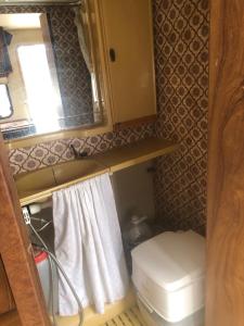 a small bathroom with a toilet and a window at Autocaravana in Port Saplaya