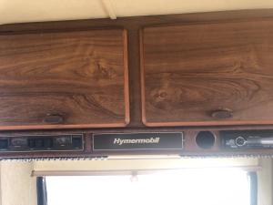 a close up of wooden cabinets in a vehicle at Autocaravana in Port Saplaya