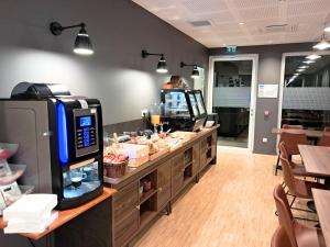 a restaurant with a counter with a cash register at Hôtel du Cheval Blanc Brunstatt in Brunstatt