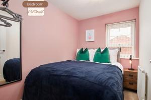 a bedroom with a large bed with green pillows at Spacious, 3BR, Coventry House | Sleeps 9 | Parking in Canley
