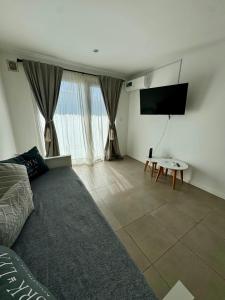 a living room with a tv and a couch and a table at NUX Tandil in Tandil