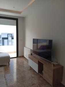 a living room with a large flat screen tv at Apartment cosy in Sidi Daoud