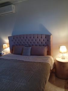 a bedroom with a large bed with a blue headboard at Apartment cosy in Sidi Daoud
