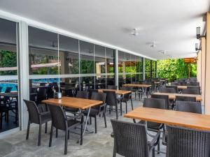 a restaurant with tables and chairs and windows at Pera Aura Resort Hotel & Spa - All Inclusive in Kemer
