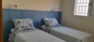 a bedroom with two beds and a window at Garden House Canastra in Delfinópolis