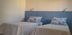 two beds sitting next to each other in a room at Garden House Canastra in Delfinópolis