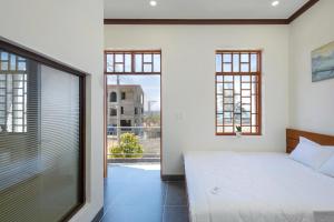 a bedroom with a bed and a large window at Homestay Hòn Đỏ Sea in Thôn Mỹ Tường