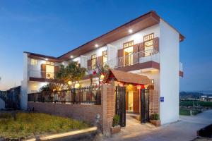 a large white house with lights on it at Homestay Hòn Đỏ Sea in Thôn Mỹ Tường