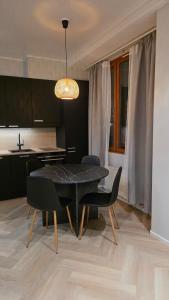 a dining room with a black table and chairs at Studio Siivilla in Uusikaupunki +4 photos