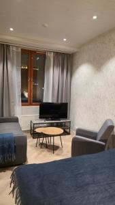 a living room with two beds and a tv at Studio Siivilla in Uusikaupunki