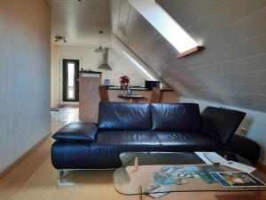 a living room with a leather couch and a table at Ferienwohnung Albus in Albertshausen
