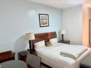 a bedroom with a bed and two lamps and a chair at Amsy hotel in Dakar